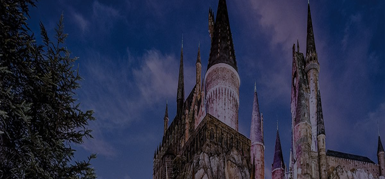 Wizarding World of Harry Potter™ castle with multiple towers against a dark blue sky - click for more details about Wizarding World of Harry Potter™!