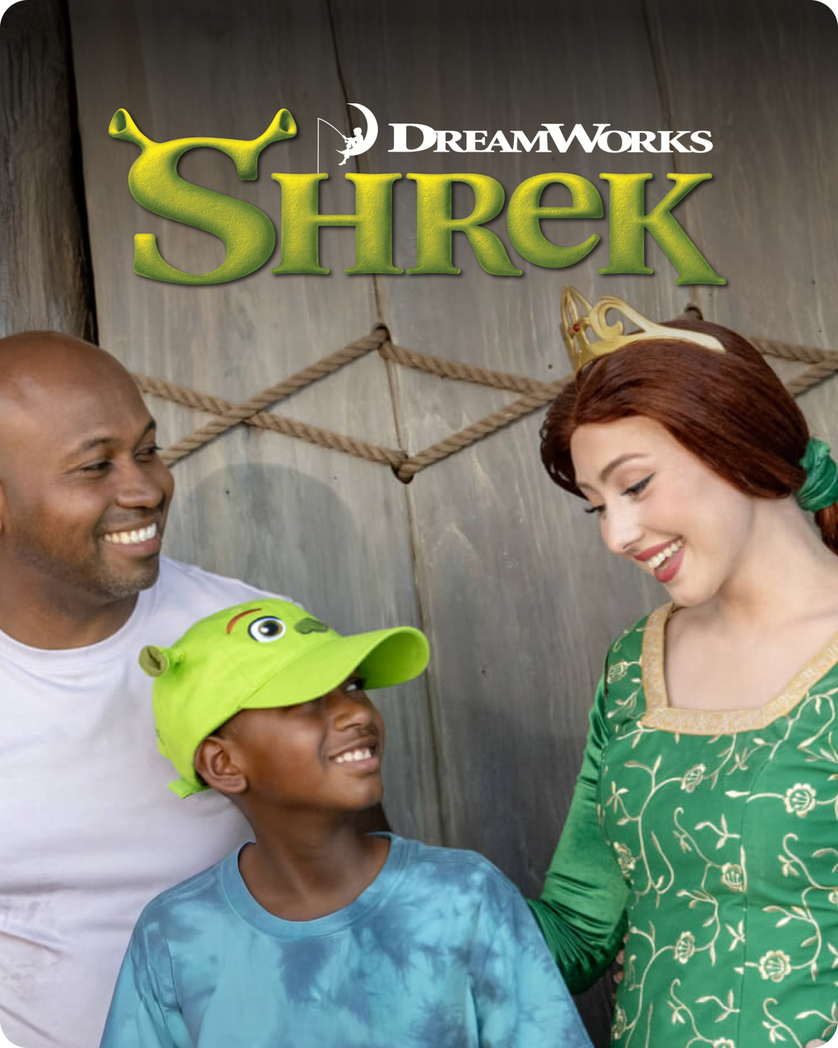 Three people posing in front of a 'Shrek' themed backdrop with DreamWorks logo - click to shop Shrek merch now!